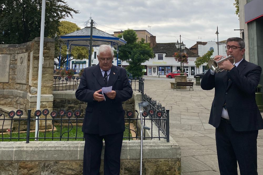 Cllr Peter Burgess pictured with bugle player