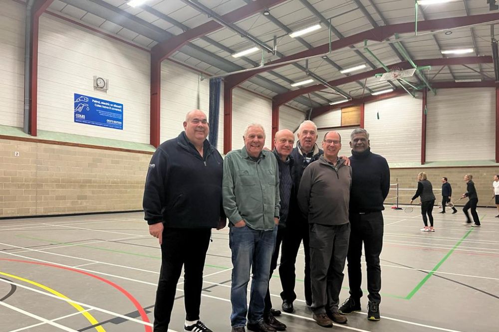 Community organisation representatives pose for a picture in the sports hall where lighting replacement will take place