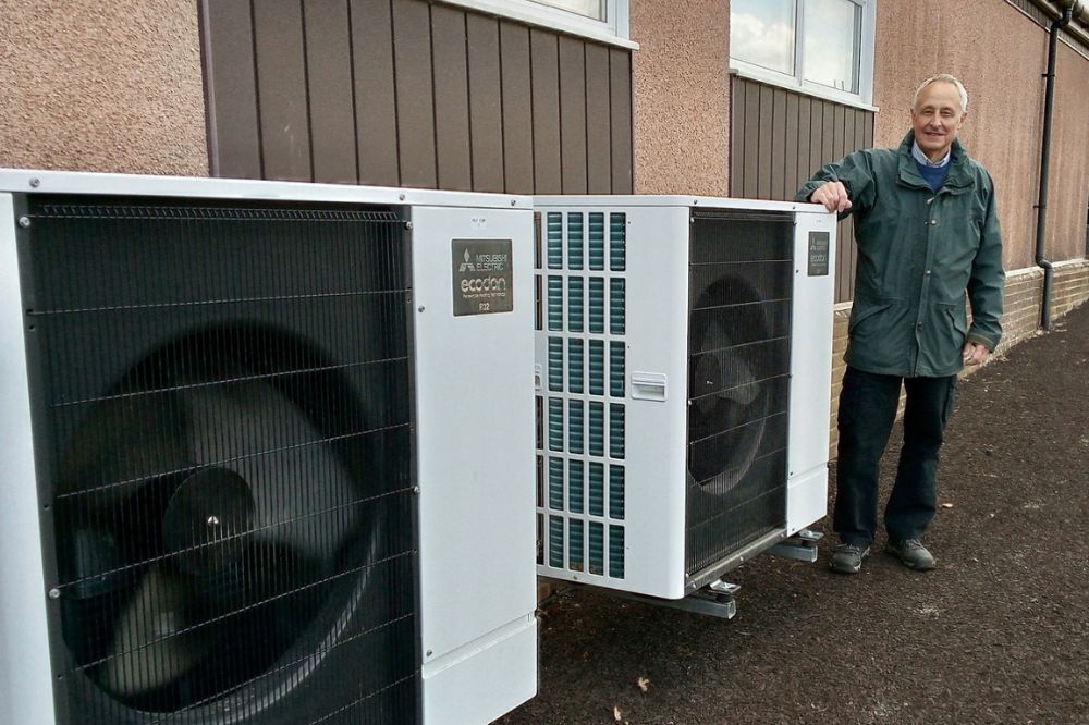 Community Climate Fund applicant stands with the new heat pumps at Southwater Village hall