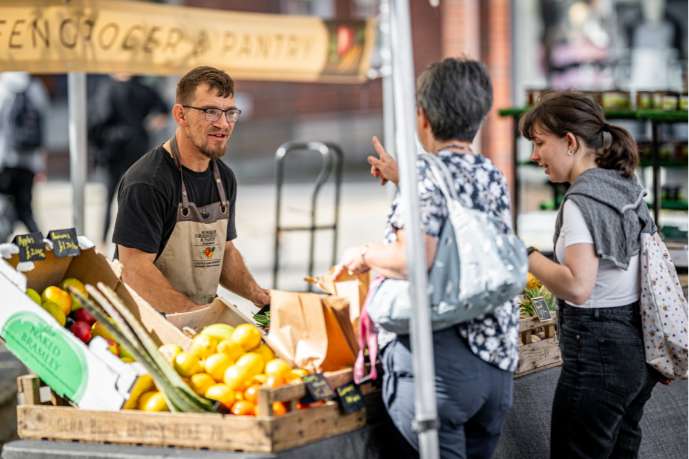 Market trader speaking with customers