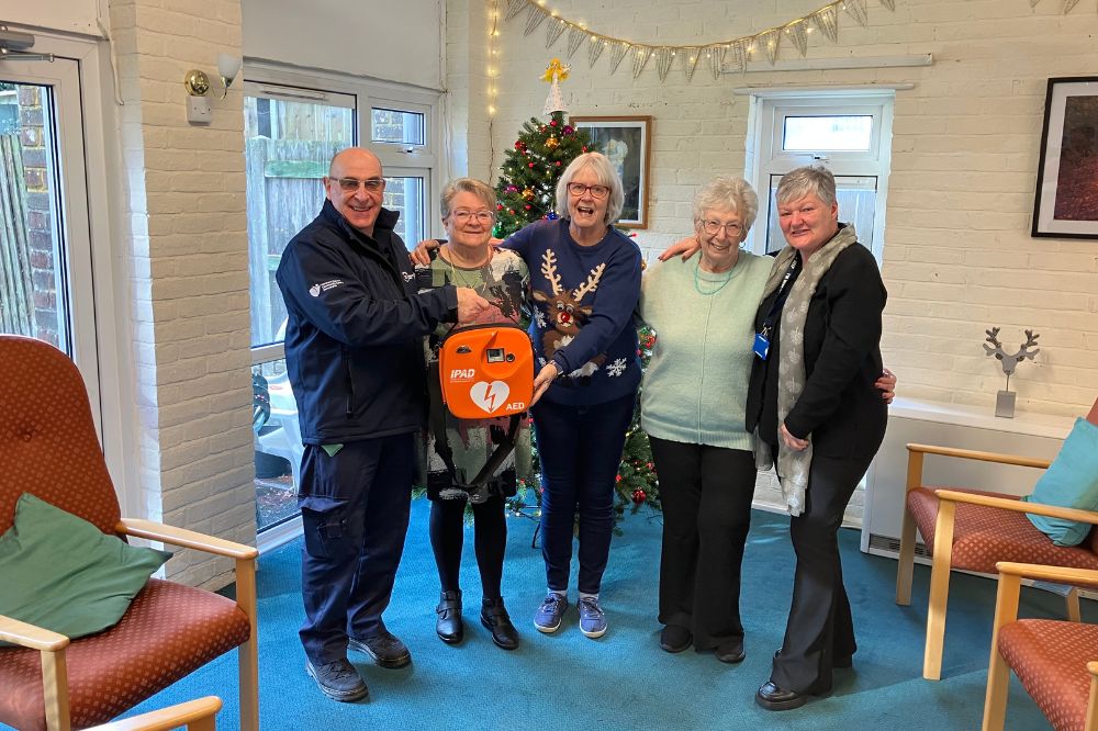 Warden Chris Poore presenting the defibrillator to the Hanover Walk Retirement Complex residents