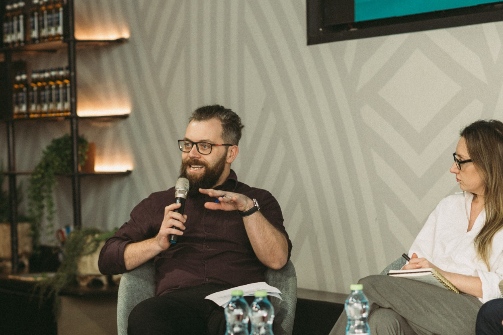 Image of a man sat down speaking into a microphone