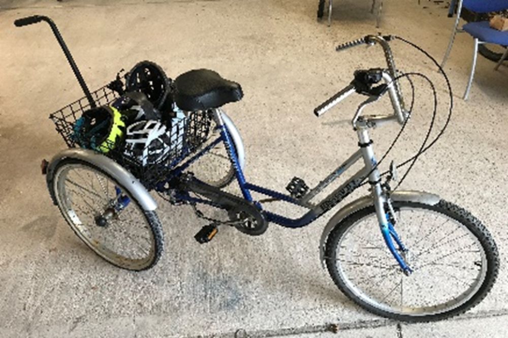 A silver trike with a standard saddle