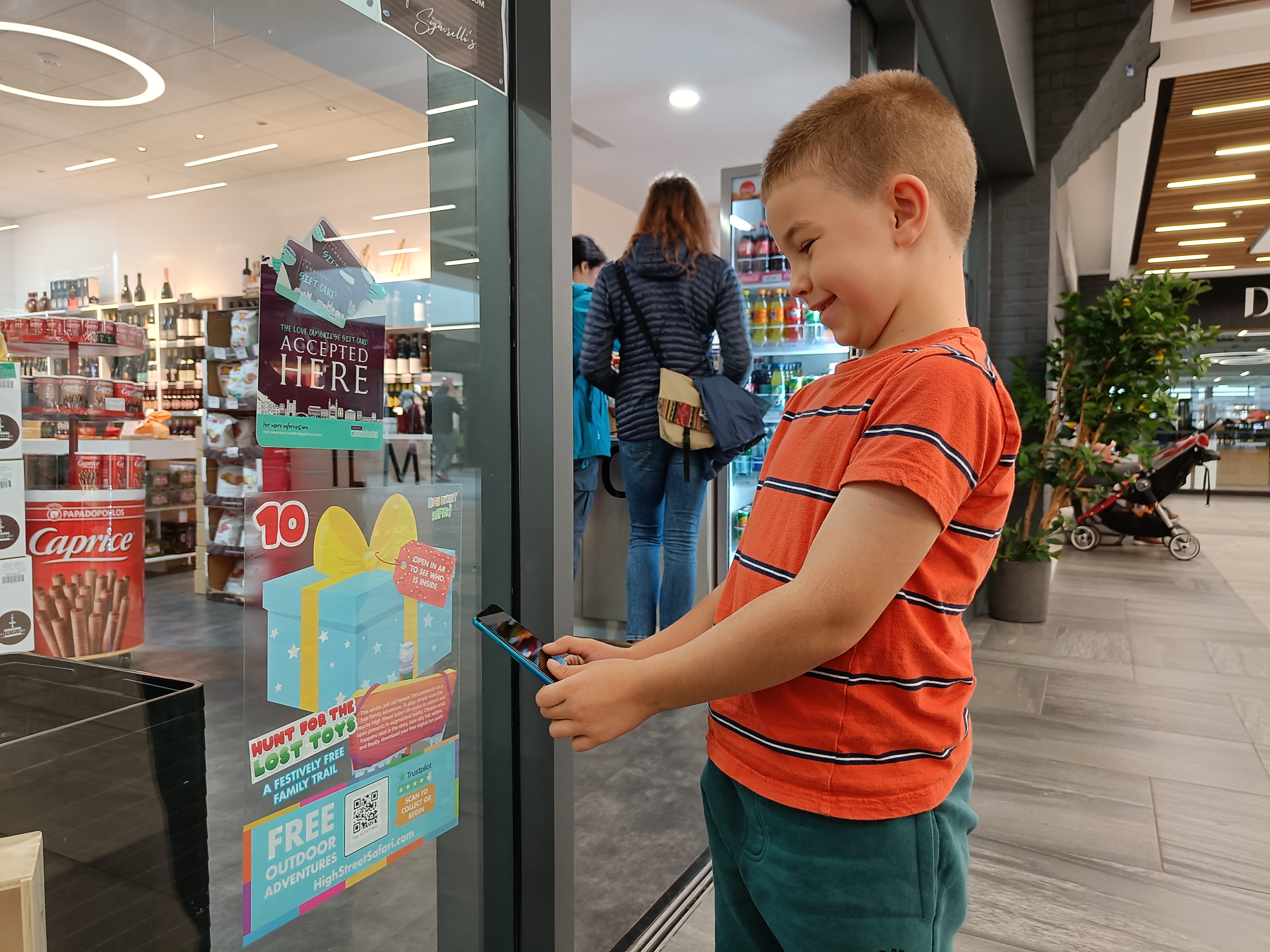 Child scanning QR code in store