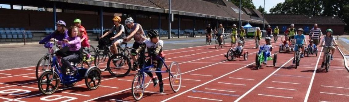 Wheels for All participants cycle on a running track