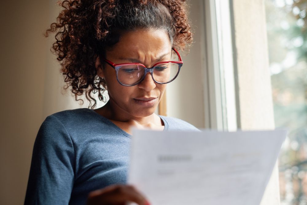 A woman looks concerned at her energy bill