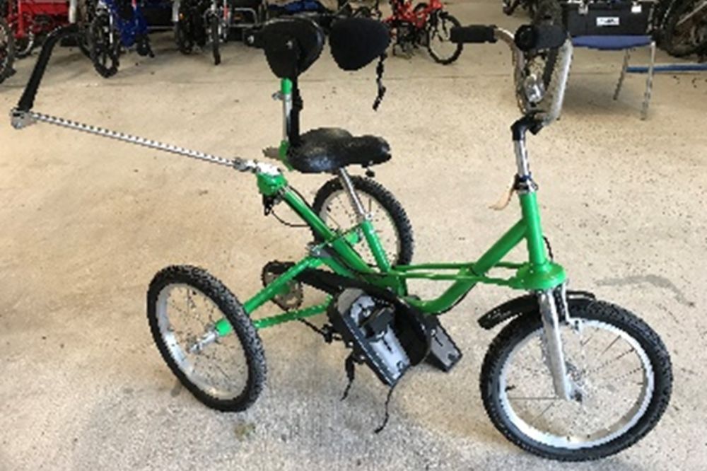 A green Tomcat 3-point trike with a waist strap for added support