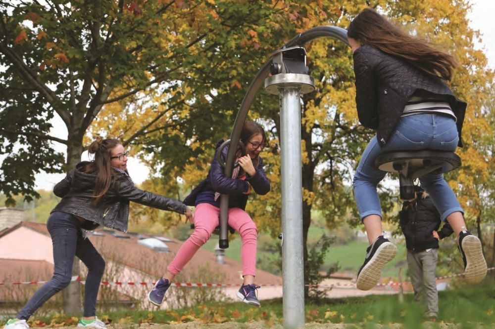 Three teen girls playing on a swing