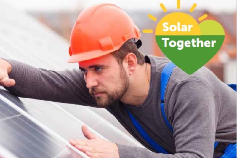 Solar Together logo and a man in a hard hat fitting a solar panel