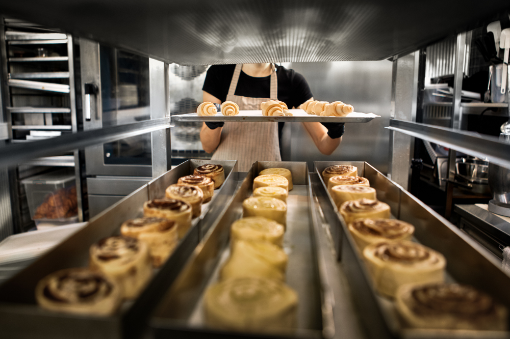 Image of person putting baked goods on a tray